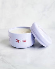 Load image into Gallery viewer, A compact white travel tin candle from Infusion Candle Co., labeled 'Spice' featuring invigorating notes of lemon, ginger, and saffron. The candle is displayed with its lid partially open, showcasing the smooth soy wax. This portable candle, handmade in Illinois, provides a warm and zesty fragrance, perfect for creating a cozy and refreshing atmosphere wherever you go. Spice travel tin candle by Infusion Candle Co